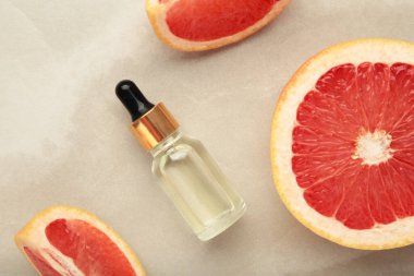 Bir şişe gerekli yağ ve arka planda taze greyfurtlar. Üst görünüm