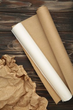 Kahverengi ahşap arka planda beyaz ve kahverengi kabartma kağıtları. Üst görünüm