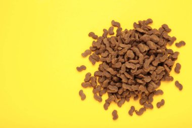 Sarı arka planda lezzetli köpek maması topları. Üst görünüm