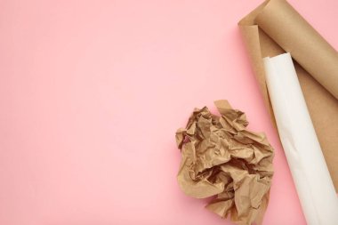 Pembe arka planda beyaz ve kahverengi kabartma kağıtları. Üst görünüm