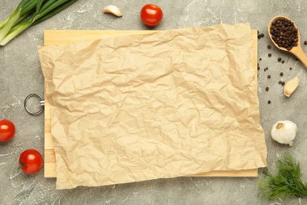 Yeşil soğanlı, sarımsaklı, baharatlı ve domatesli fırın kağıdı mavi ahşap arka planda. Yemek pişirme konsepti. Üst görünüm