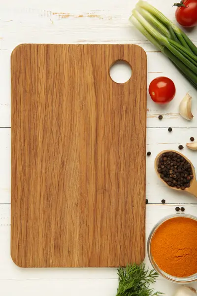 Kesme tahtası, yeşil soğan, sarımsak, baharatlar ve domatesler beyaz ahşap arka planda. Yemek pişirme konsepti. Üst görünüm