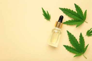 CBD yağlı cam şişeler, THC tentür, bej arka planda kenevir yaprakları. Düzlük, minimalizm. Kozmetik CBD kenevir yağı