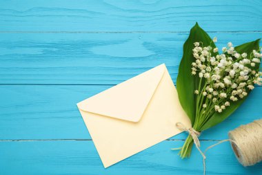 Bir el sanatları zarfında davetiye. Mavi arka planda vadinin zambaklarından oluşan bir buket. Üst görünüm