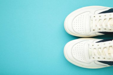 Beyaz ayakkabılar, mavi arka planda spor ayakkabılar. Uniseks spor ayakkabıları.