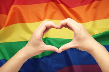 Eller LGBT bayrağına karşı sevgi ve kalp gösteriyor. Üst görünüm