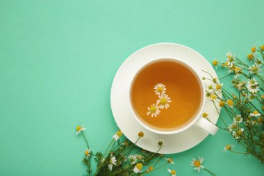 Beyaz fincanda aromatik bitki çayı ve naneli papatya çayı. Üst görünüm