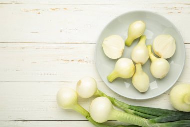 Beyaz ahşap kaplama tabakta yeşil soğan. Üst görünüm