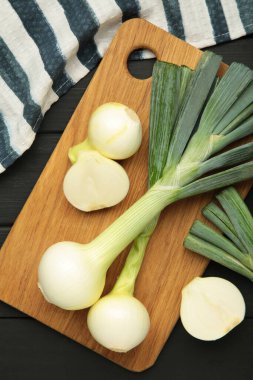 Siyah ahşap arka planda yeşil soğan. Üst görünüm