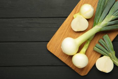 Siyah ahşap arka planda yeşil soğan. Üst görünüm