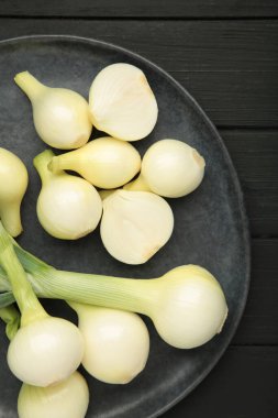 Siyah ahşap arka planda yeşil soğan. Üst görünüm