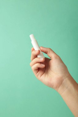 Nane arkaplanda doğal dudak kremi olan bir kadın eli. Üst görünüm