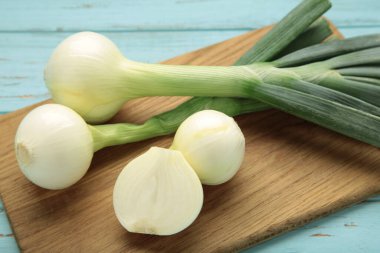 Mavi ahşap arka planda yeşil soğan. Üst görünüm