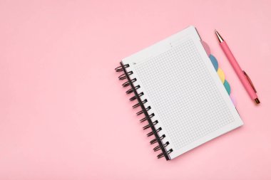 Pembe arka planda pembe kalemli defter. Üst görünüm