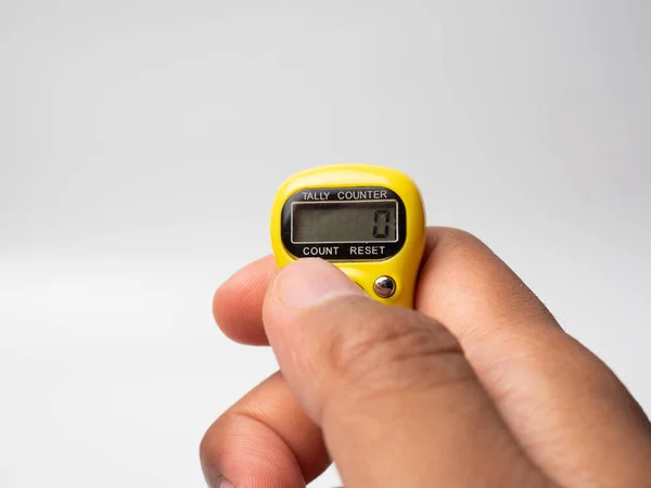 Picture of a yellow digital tally counter on a white background