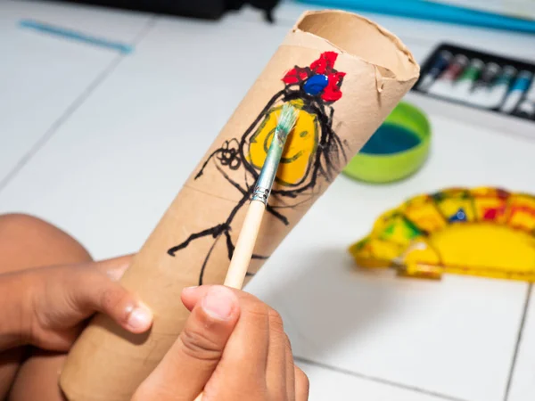 Kids painting on a paper tube