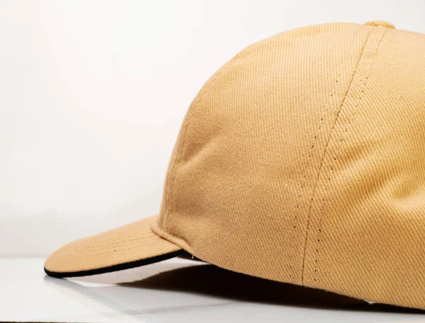 Side view of a brown baseball hat on a white background