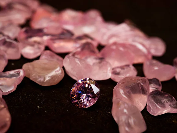 Sparkling round cut pink colored diamond on black background
