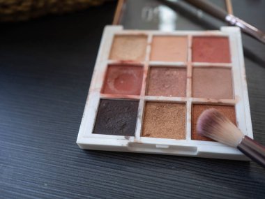 Siyah ahşap bir masada fırça ve göz farı paleti yap..