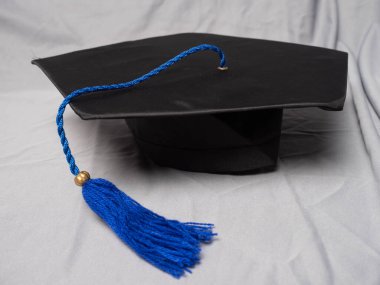 Gri bir arka planda mavi püsküllü siyah havan topu.