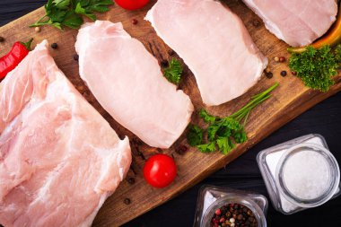 Kesme tahtasındaki çiğ domuz etli biftek. Üst görünüm