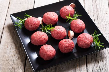 Ahşap arka planda çiğ et köftesi. Ön görünüm