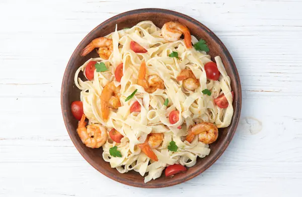 Italian pasta with shrimps , parmesan and tomatoes. Fettuccine in a creamy sauce top view