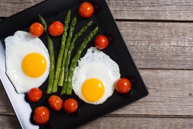 Yumurta, kuşkonmaz ve domatesli sağlıklı bir kahvaltı. Sebze arka planı