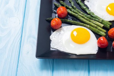 Yumurta, kuşkonmaz ve domatesli sağlıklı bir kahvaltı. Sebze arka planı