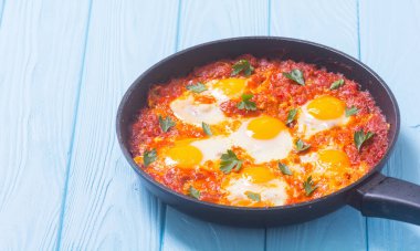 Geleneksel İsrail yemekleri Shakshuka. Domates soslu kızarmış yumurta.