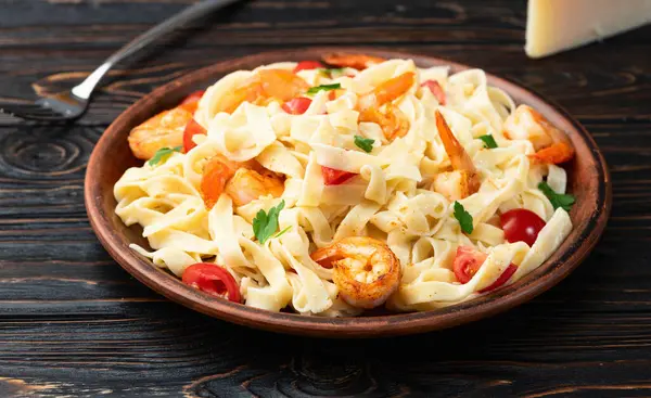 stock image Italian pasta with shrimps , parmesan and tomatoes. Fettuccine in a creamy sauce top view