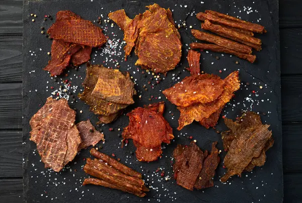 Mischung Aus Getrocknetem Fleisch Jerky Von Huhn Rind Und Schwein lizenzfreie Stockbilder