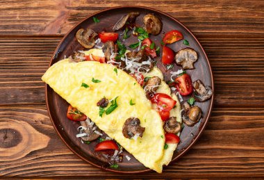 Mantar, domates ve maydanozla doldurulmuş omlet. Üst görünüm