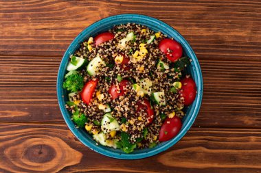 Kinoa brokoli, salatalık, domates ve mısırlı taze sebze salatası.