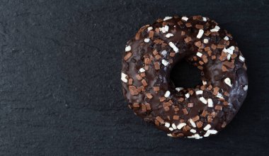 Ahşap arka planda renkli çörekler. Çikolata, limon, portakal ve ahududu. Üst görünüm