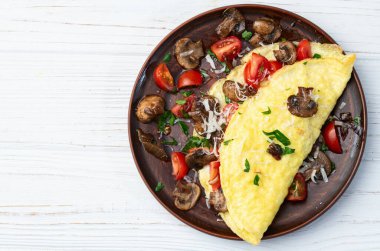 Mantar, domates ve maydanozla doldurulmuş omlet. Üst görünüm