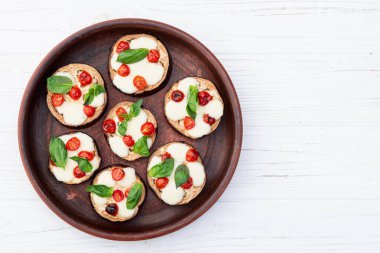İtalyan mini pizzası. Patlıcan peynirli ve fesleğenli. Kırsal arkaplan üstü görünümünde