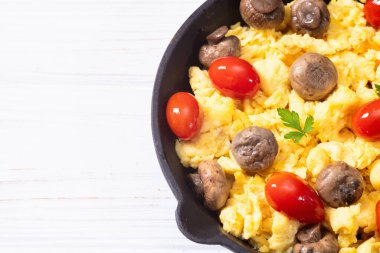 Sağlıklı vejetaryen kahvaltısı. Tavada yumurta, kiraz domatesli ve maydanozlu. Üst görünüm