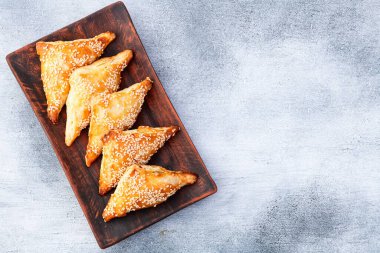 Köy arka planında etli ev yapımı üçgen puf böreği. Samosa Üst Görünümü 