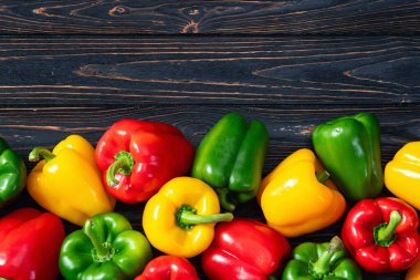 Taze tatlı dolmalık biber (kırmızı biber) fotoğraf kırmızı, yeşil ve sarı. Renkli sebze. Kırsal arkaplanda üst görünüm