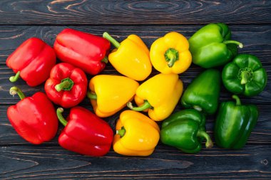 Taze tatlı dolmalık biber (kırmızı biber) fotoğraf kırmızı, yeşil ve sarı. Renkli sebze. Kırsal arkaplanda üst görünüm