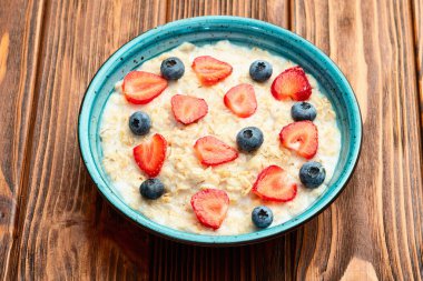 Ev yapımı kahvaltı. Sütlü ve dutlu yulaf ezmesi. Kırsal arkaplanda üst görünüm