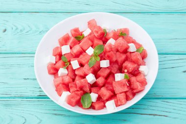 Peynirli ve naneli yaz karpuz salatası. Ahşap arkaplanda üst görünüm