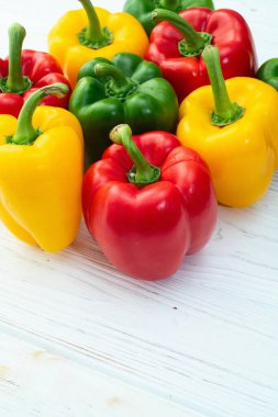 Taze tatlı dolmalık biber (kırmızı biber) fotoğraf kırmızı, yeşil ve sarı. Renkli sebze. Kırsal arkaplanda üst görünüm