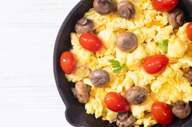 Sağlıklı vejetaryen kahvaltısı. Tavada yumurta, kiraz domatesli ve maydanozlu. Üst görünüm