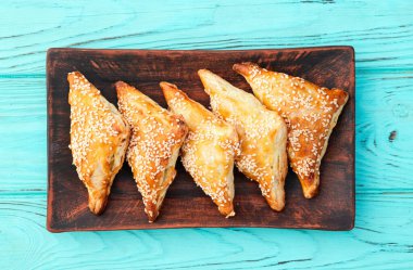 Köy arka planında etli ev yapımı üçgen puf böreği. Samosa Üst Görünümü 