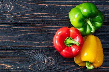 Taze tatlı dolmalık biber (kırmızı biber) fotoğraf kırmızı, yeşil ve sarı. Renkli sebze. Kırsal arkaplanda üst görünüm