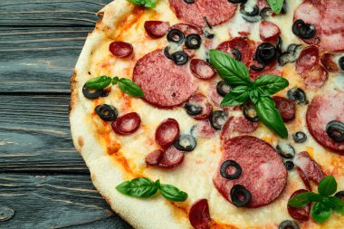 Mozzarella peynirli pizza, salam sosisi, zeytin ve fesleğen. Üst manzara peperonisi