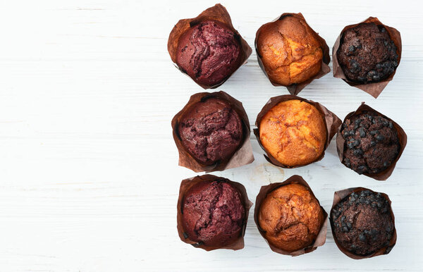 Mix of muffins ( cupcake ) chocolate , vanilla , berries . Top view photography