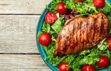 Kızarmış tavuk göğsü (fileto) lahana salatası ve kiraz domatesli. Kırsal arkaplanda üst görünüm